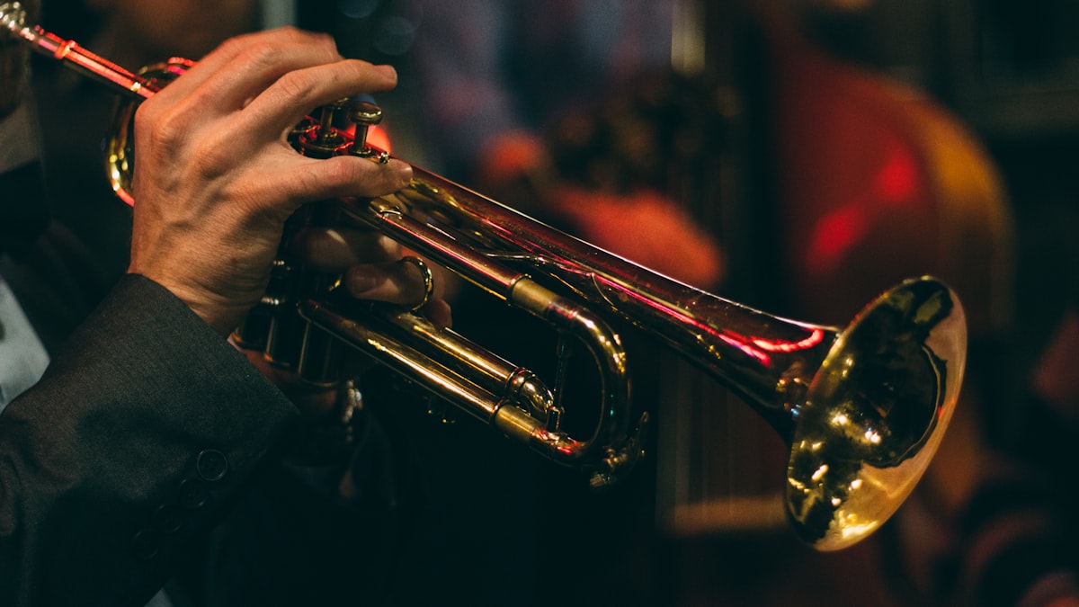 A close-up view of a musician's hands playing the keys of a saxophone.