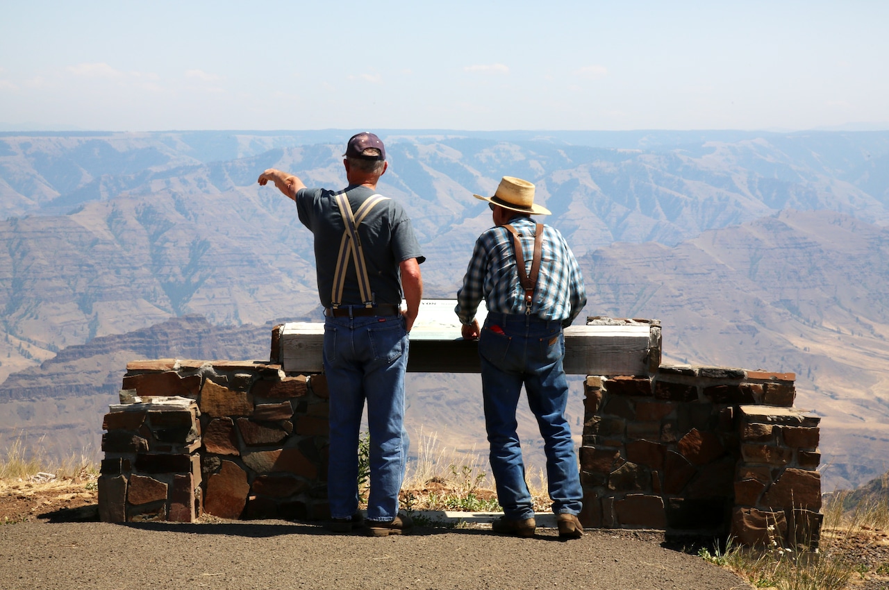 A wide panoramic view of the deep river gorge and layered mountains of Hells Canyon.