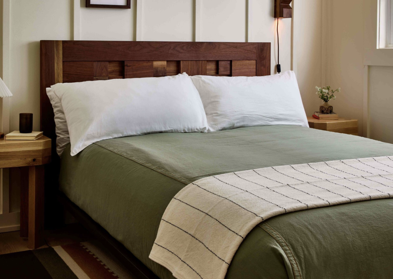 A modern rustic private King room with plush bedding and warm lighting.