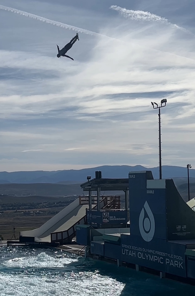 An athlete performing a freestyle ski jump into a training pool at Utah Olympic Park.