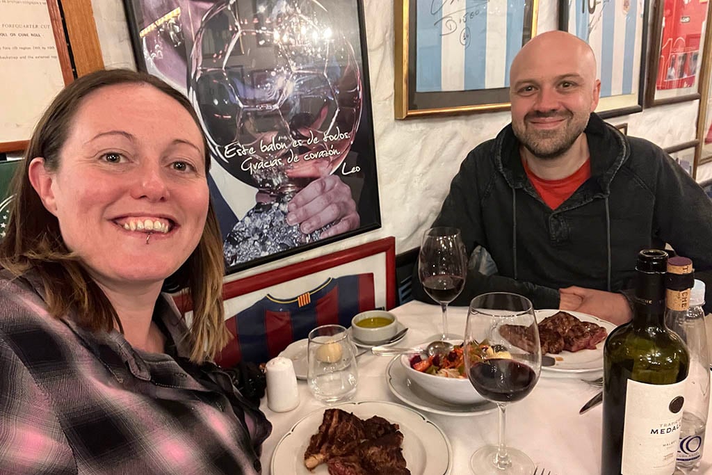 Plates of thick-cut Argentine beef served at a traditional wood-paneled parrilla.