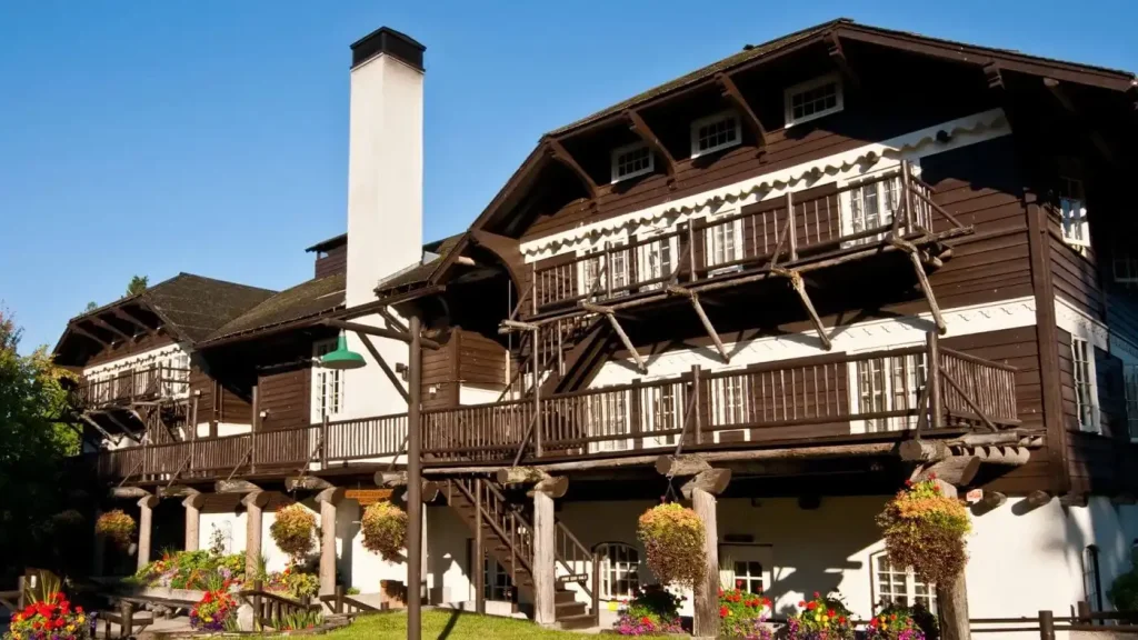 The wooden exterior of the historic Lake McDonald Lodge surrounded by tall evergreen trees.