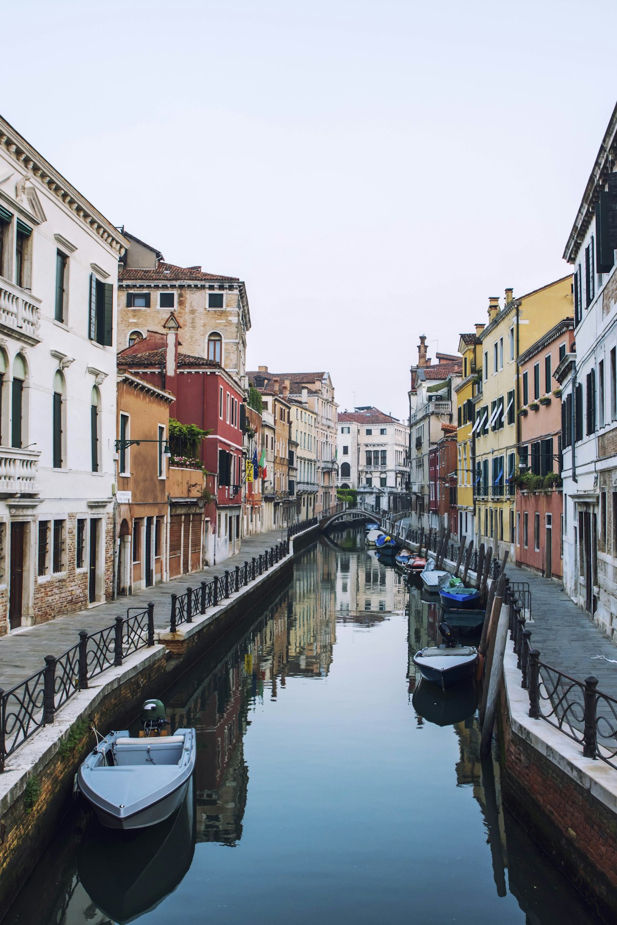 A quiet Venetian canal with colorful buildings and traditional shutters in the Santa Croce neighborhood.