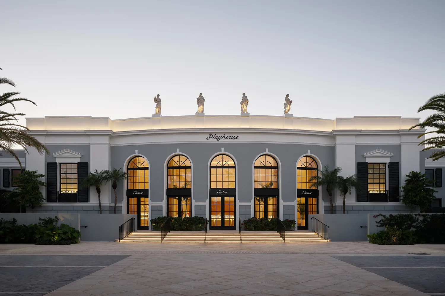 The grand arched windows and palm-flanked entrance of the Cartier boutique in Palm Beach.