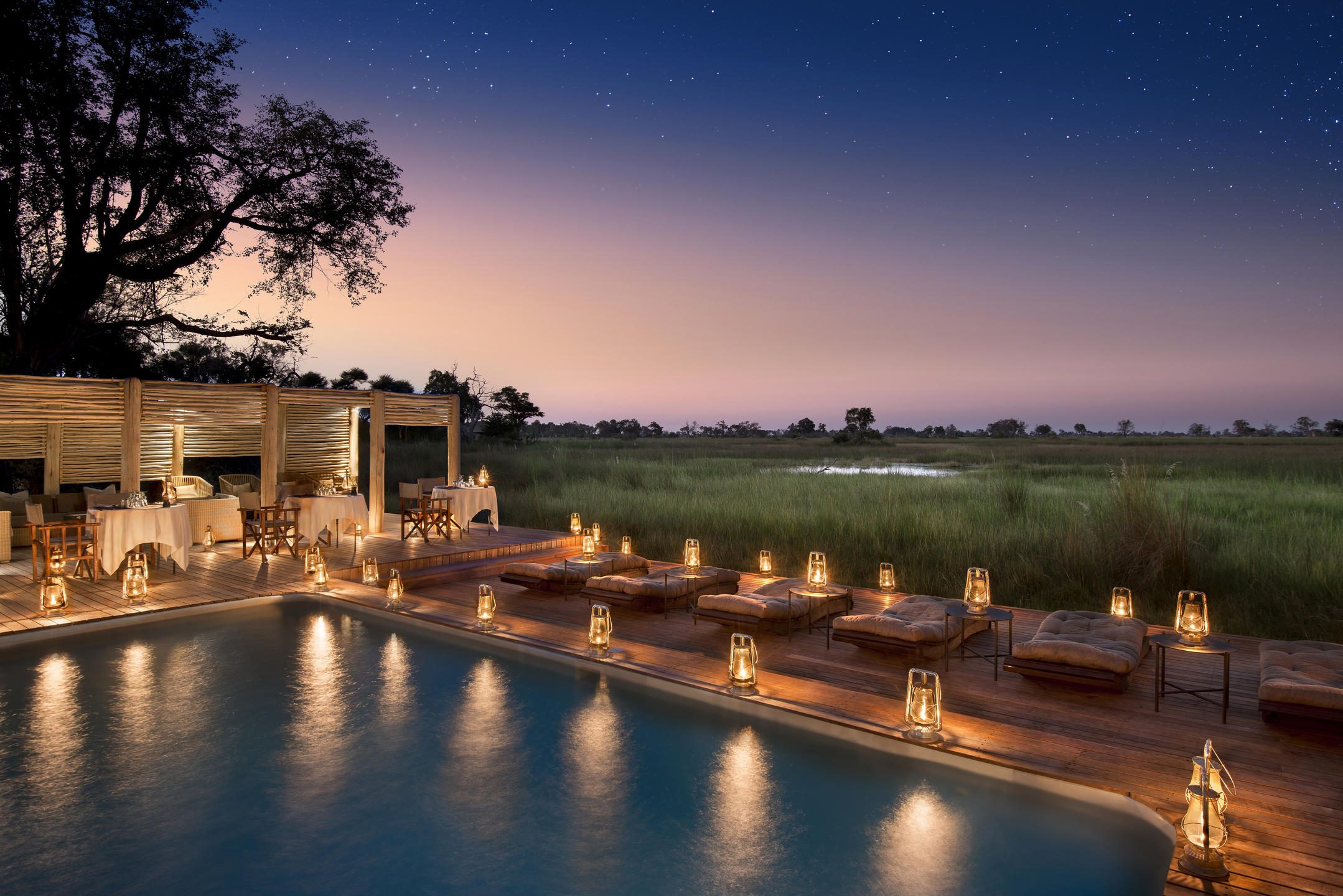 Aerial view of a luxury tented camp nestled within the lush greenery of the Okavango.