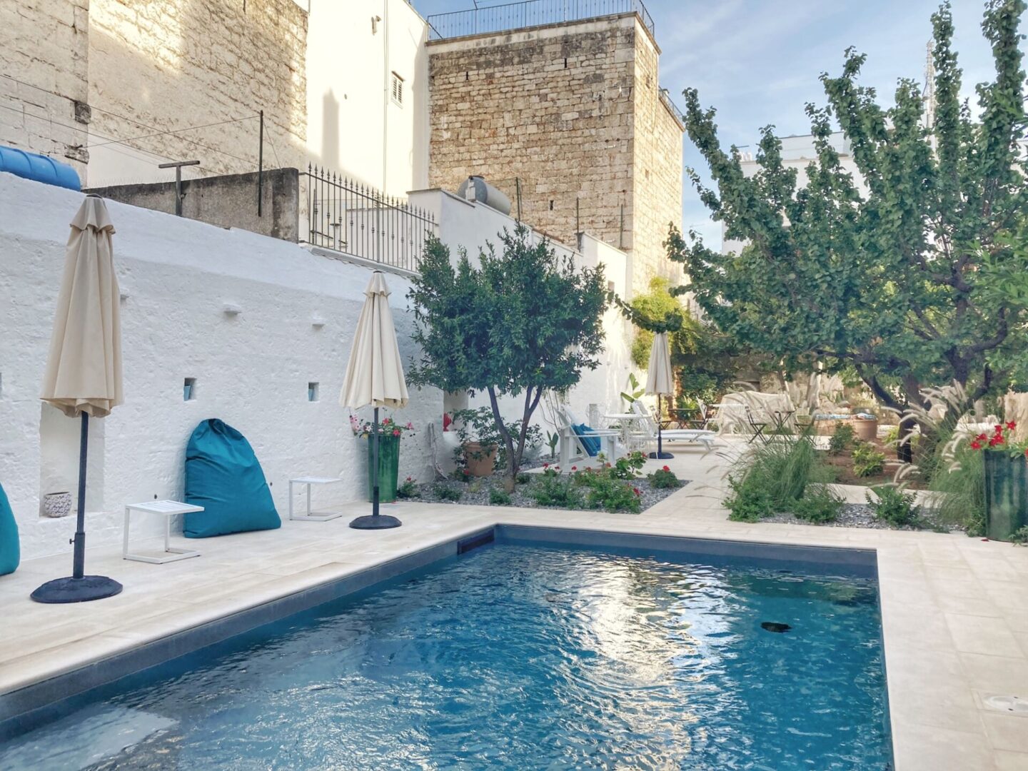 The whitewashed buildings of Polignano a Mare perched on limestone cliffs above a small turquoise bay.