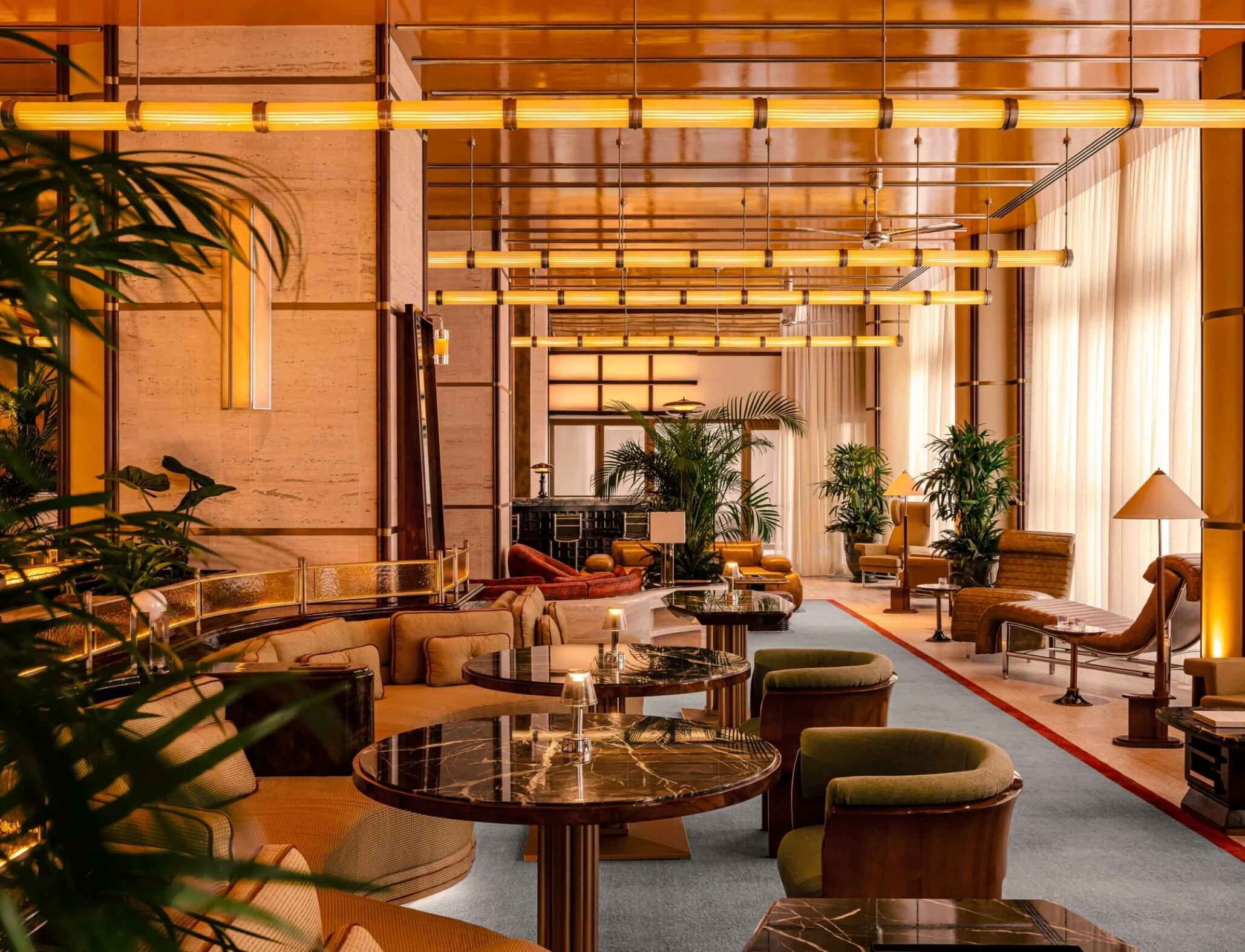 Warmly lit luxury lounge interior on the La Dolce Vita Orient Express with brass accents and plush seating.