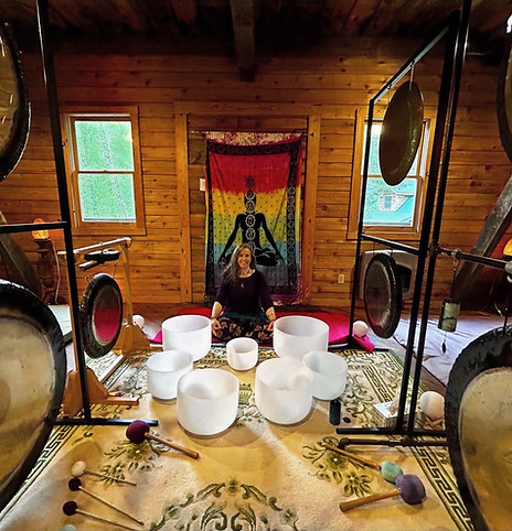 A person lying down with eyes closed during a professional sound healing session with singing bowls.