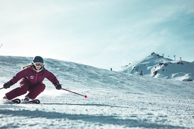 A young girl in ski gear skiing down a snow-covered slope at a Turkish ski resort.