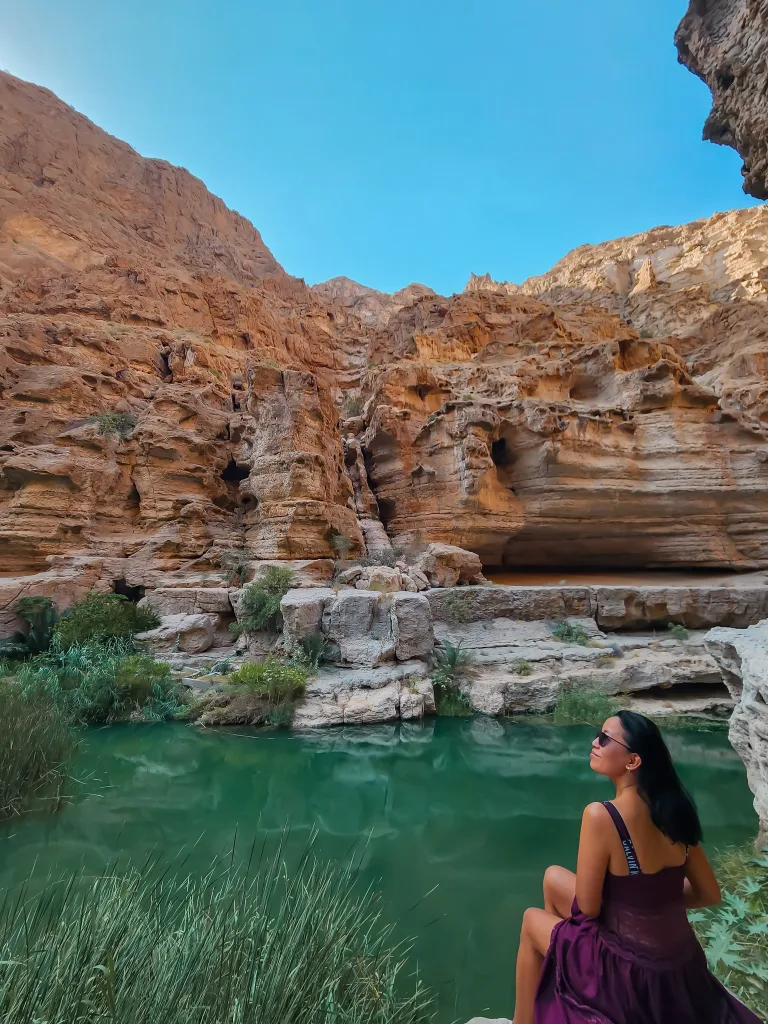 Turquoise natural pools nestled between towering limestone cliffs in Wadi Shab.
