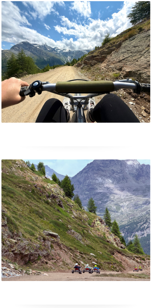 People riding mountaincarts down a winding dirt path in the Swiss Alps.