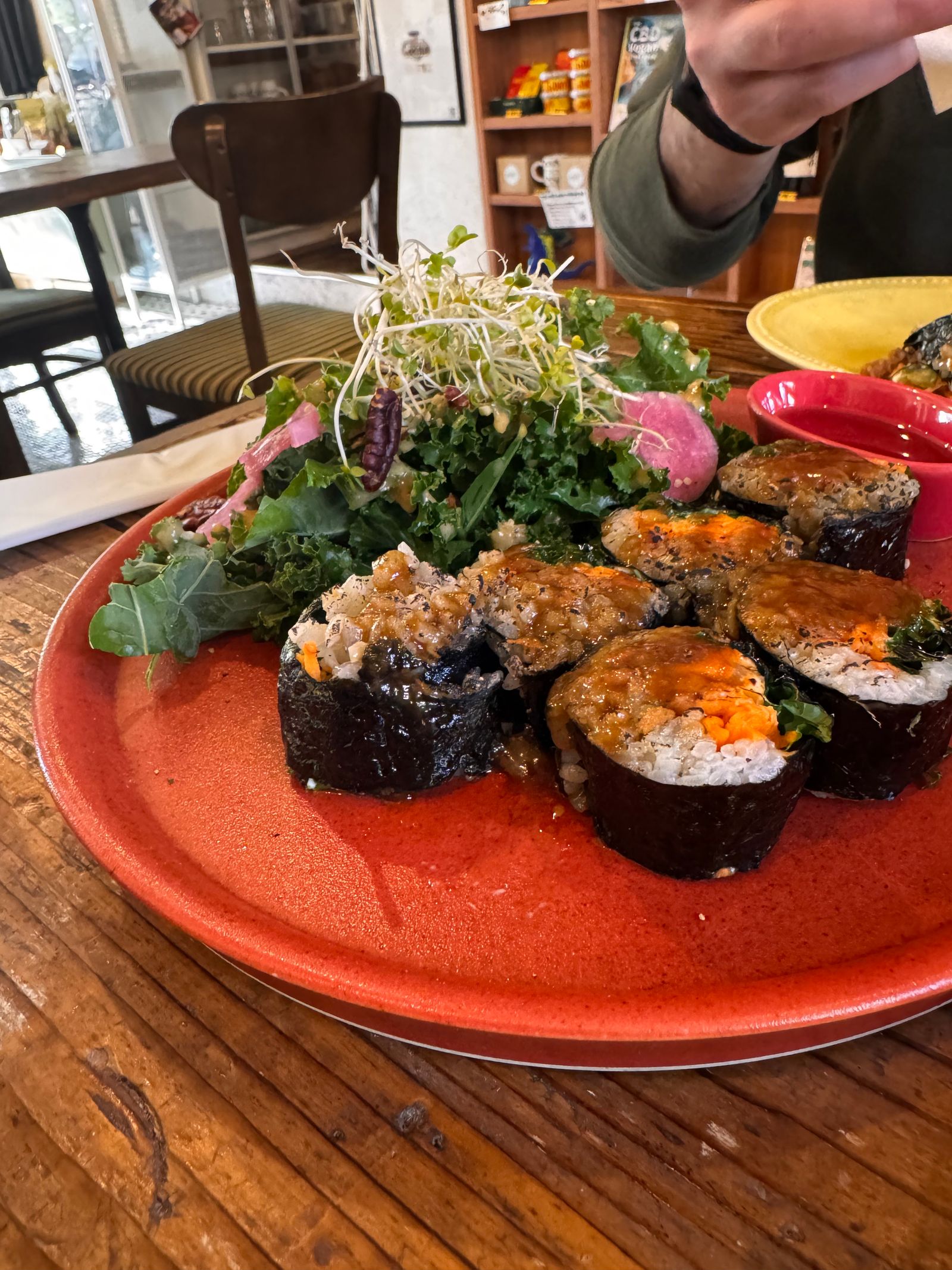 A chef or server presenting a beautifully plated dish in a high-end restaurant setting.