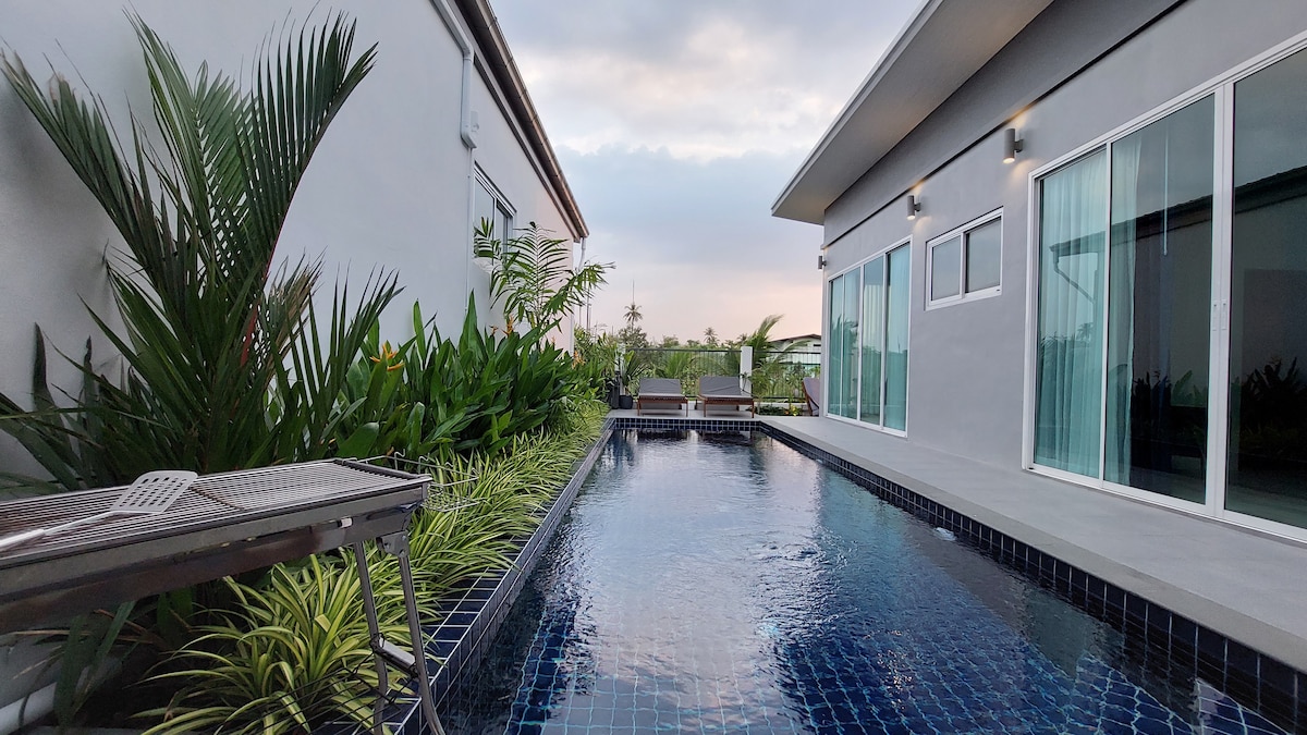 A private swimming pool surrounded by dense tropical trees and greenery.