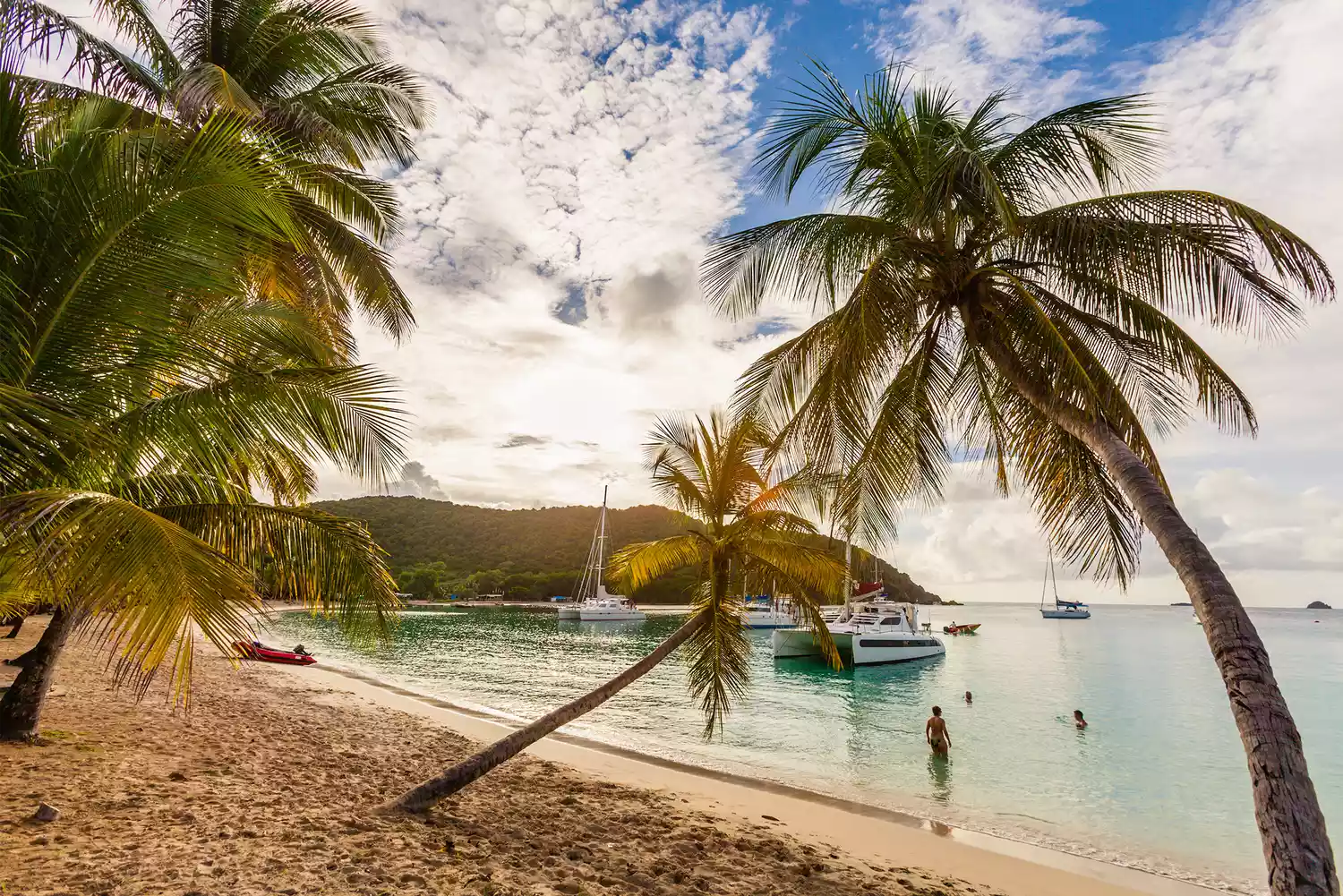 People swimming and relaxing on the white sands of Salt Whistle Bay