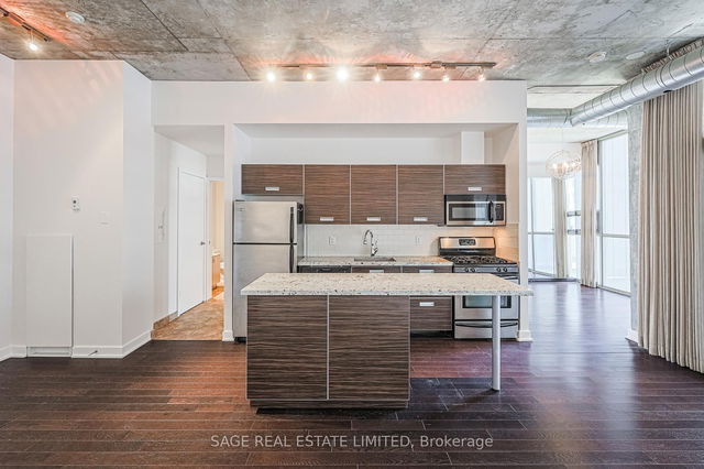Interior of a modern condo loft with large windows and industrial accents at 60 Bathurst Street.