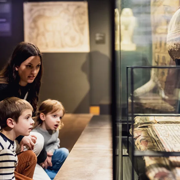 A family looking at large-scale artwork inside a bright, modern museum gallery.