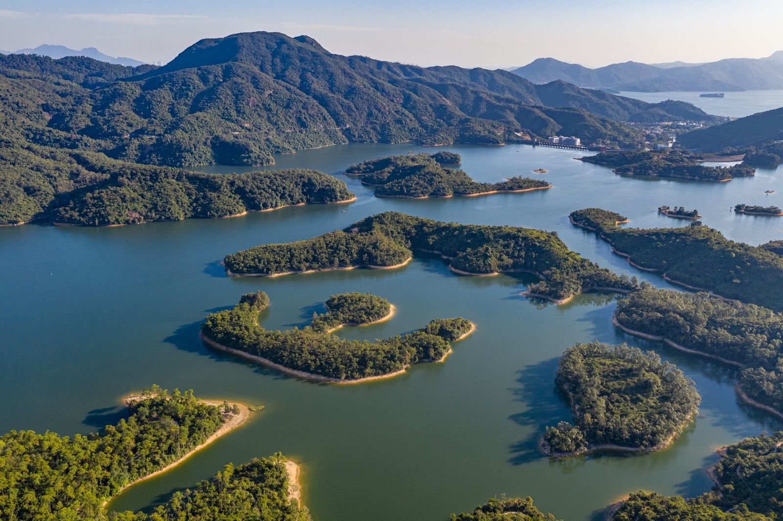 Aerial view of lush green islands scattered across a blue reservoir.