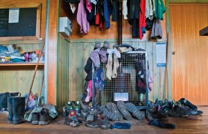 A wooden hiking shelter, Pelion Hut, situated in a valley on the Overland Track.