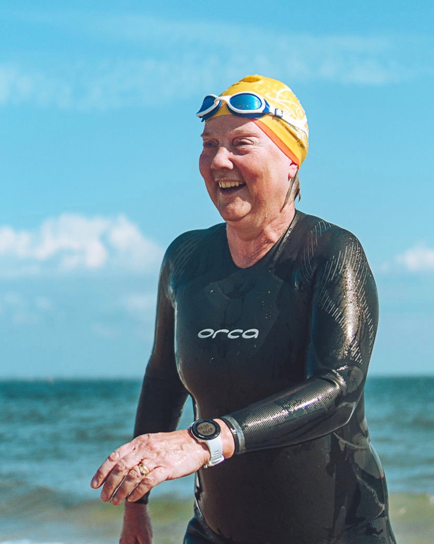 Open water swimmers moving in a group through deep blue ocean water in Dorset.