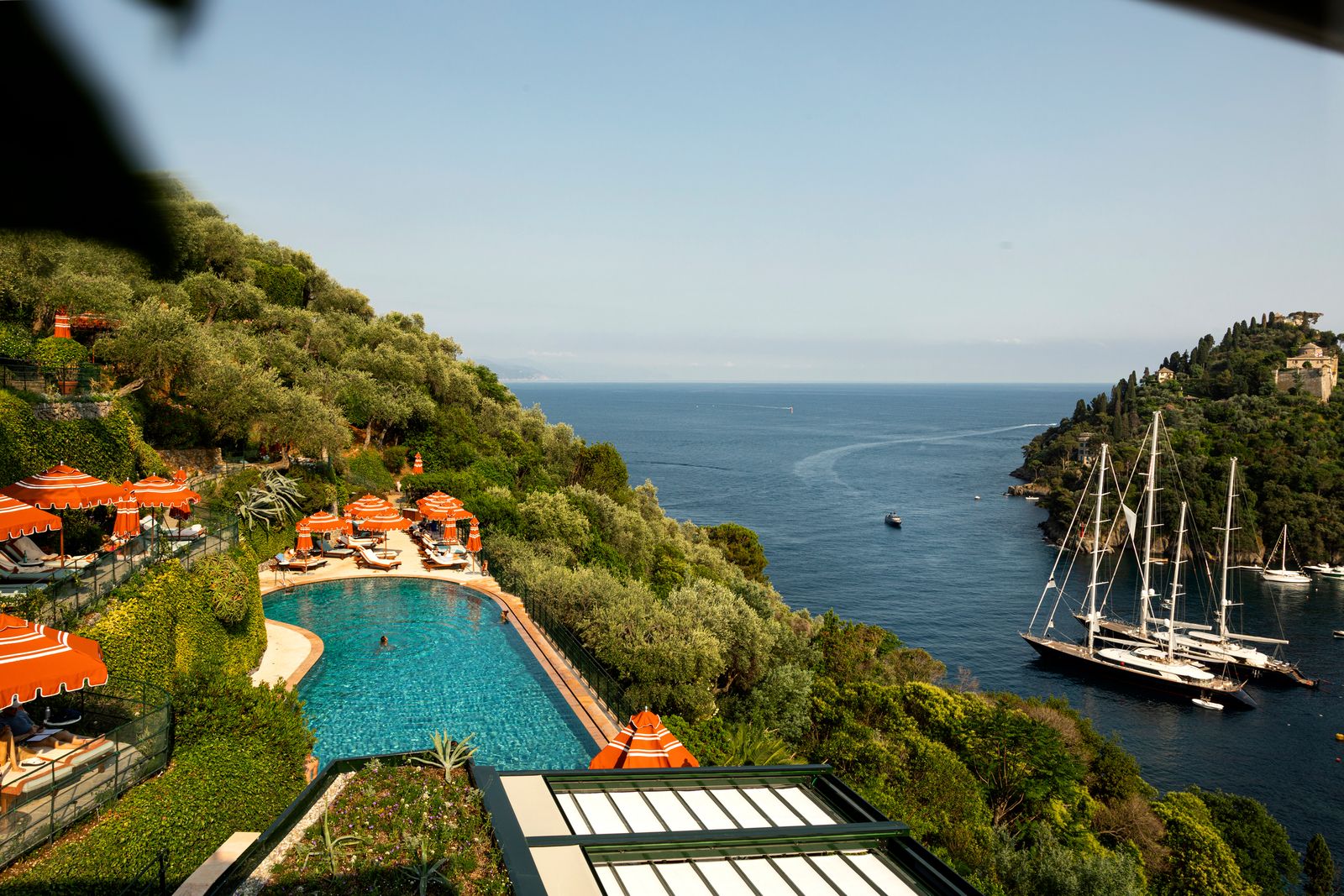 A luxury infinity pool overlooking a Mediterranean bay at a high-end hotel.