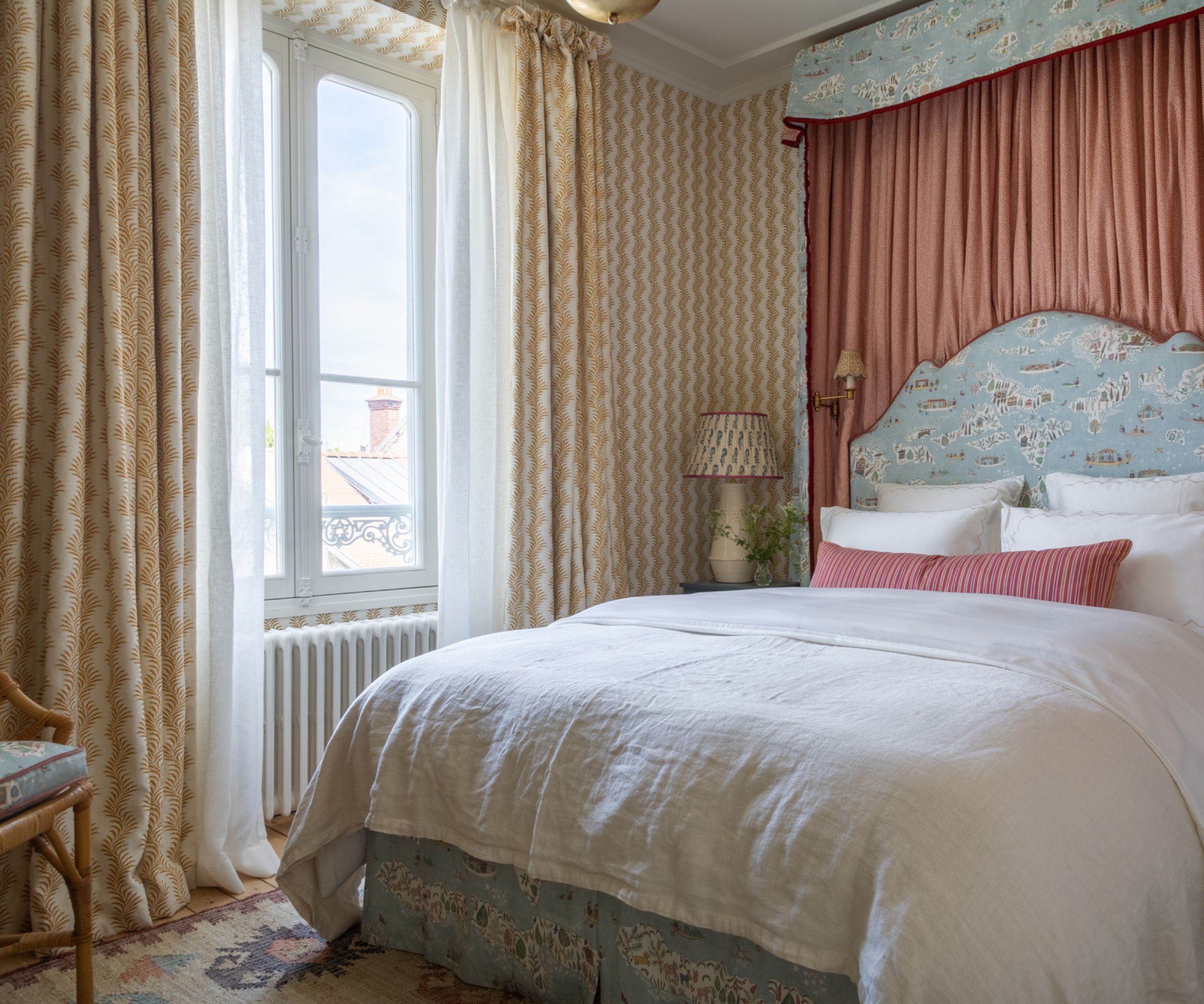 A hotel-style bedroom featuring a modern blue canopy bed and striped wallpaper.