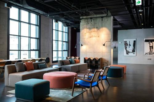 Contemporary industrial-style hotel room with green accents and artistic lighting