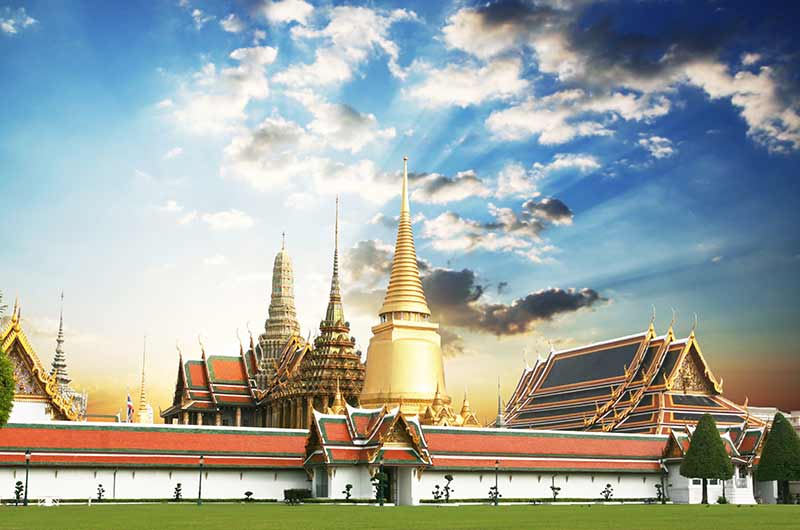 The ornate golden spires and intricate facades of the Grand Palace and Wat Phra Kaew in Bangkok.