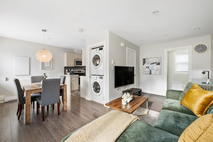 A bright two-level modern laneway house with large windows and a clean white exterior.