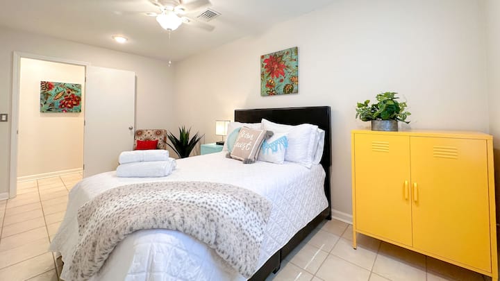 Large living area with multiple seating options and TVs in a spacious Tallahassee rental house.