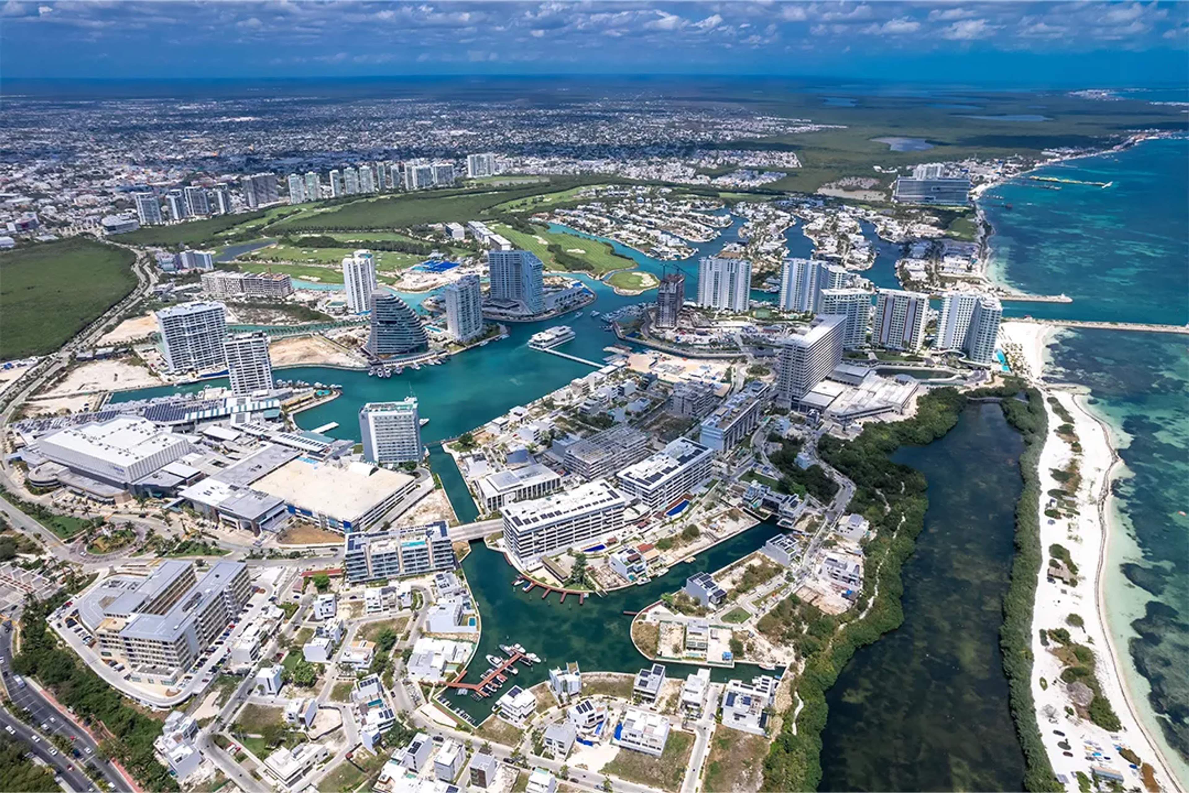 Aerial view of high-end resorts and winding waterways in a modern district of Cancún.