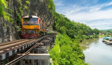 Historic temple ruins and traditional architecture along the riverside near Bangkok.