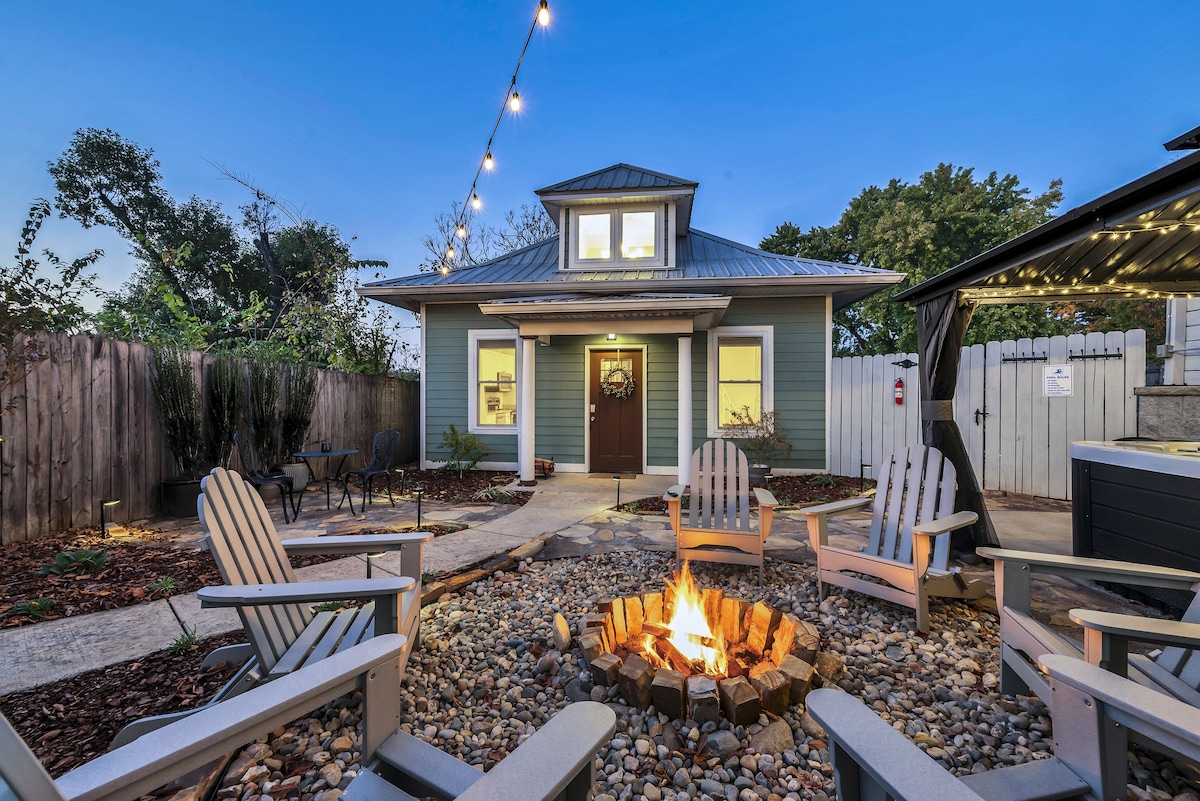 An inviting outdoor courtyard with a fire pit, seating area, and lush landscaping.