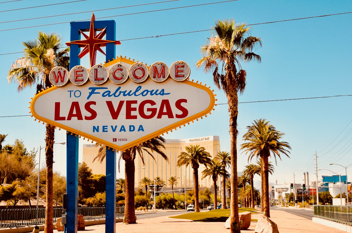 Wide-angle aerial shot of the Las Vegas Strip at night with glowing neon signs and resort lights.