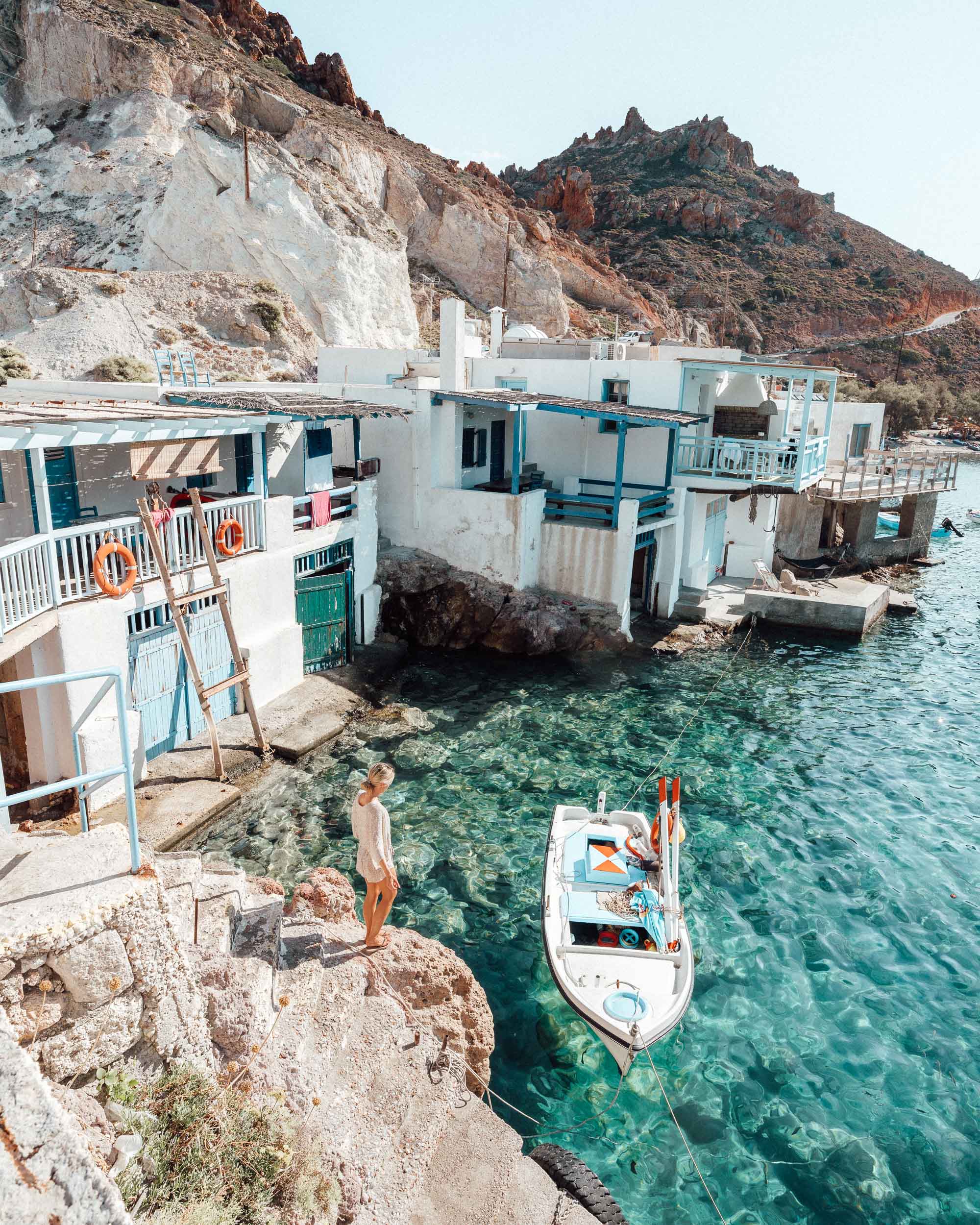 The small church and whitewashed houses of Firopotamos Beach nestled against rocky cliffs.
